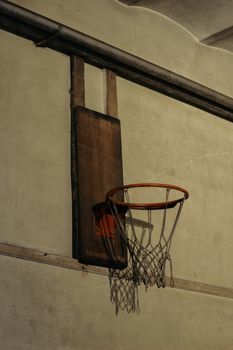 Rustic wooden basketball hoop with net inside an old İstanbul gym, capturing a retro feel.