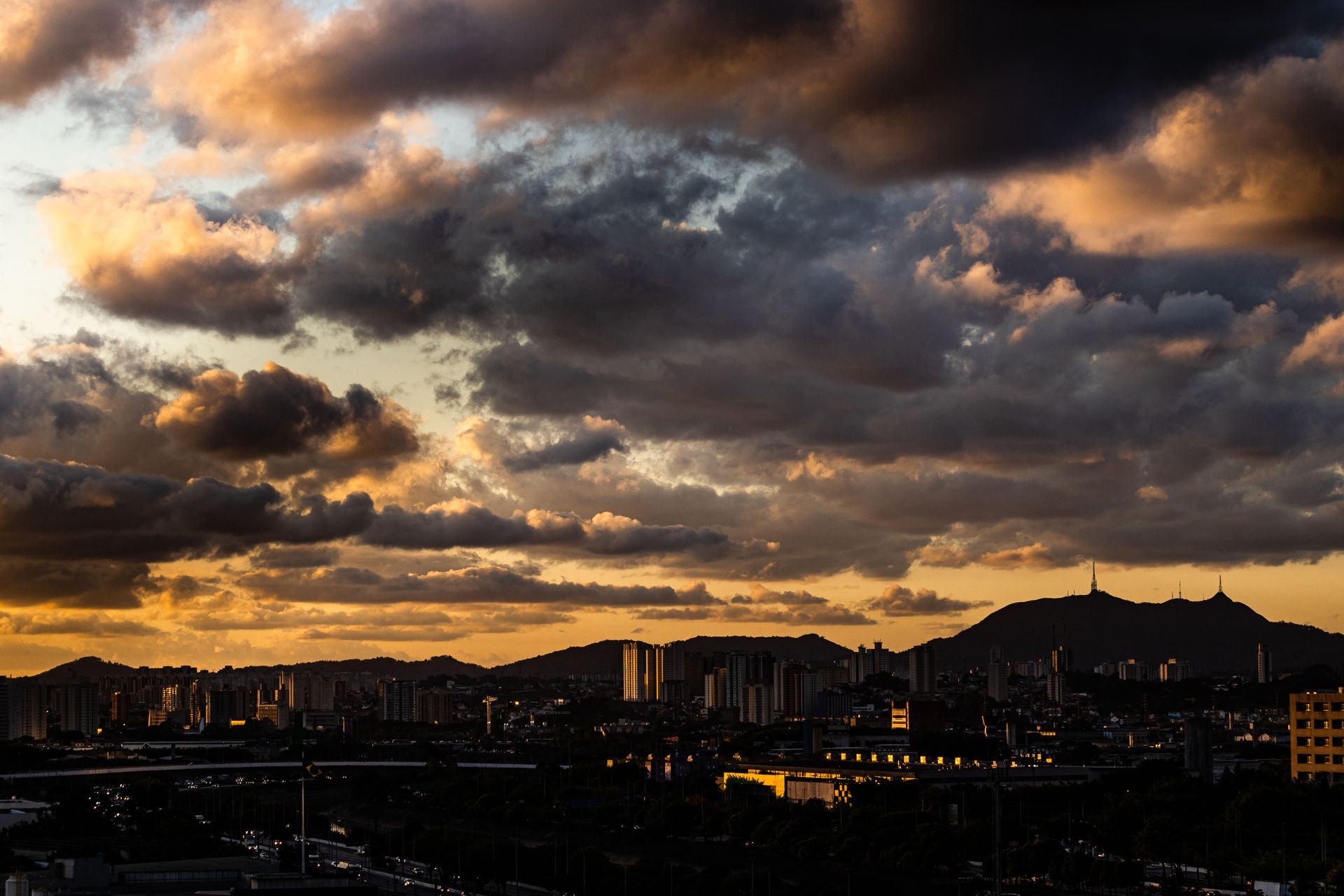 Captivating skyline of São Paulo with moody clouds and sunrise hues.