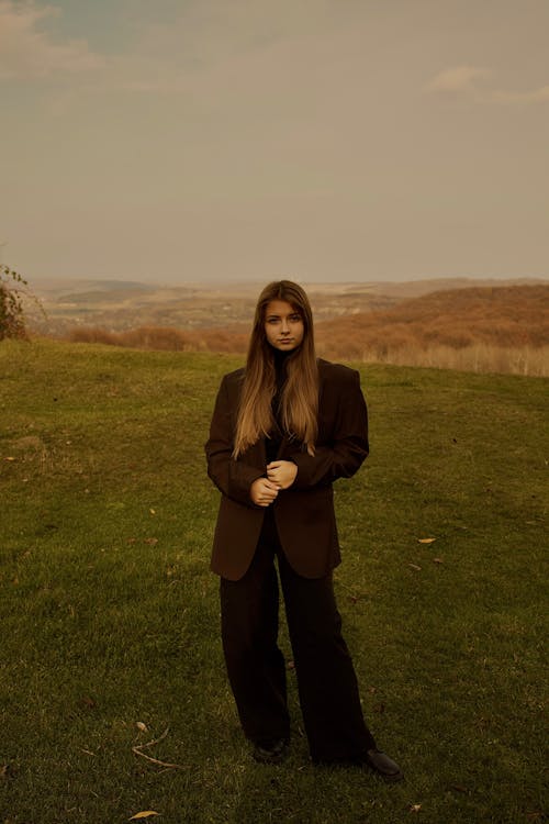 Blonde Woman Standing on Meadow Wearing Suit
