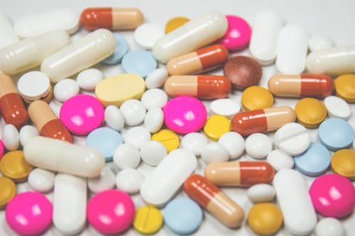 Pile of White Pink and Brown Oblong and Round Medication Tablet