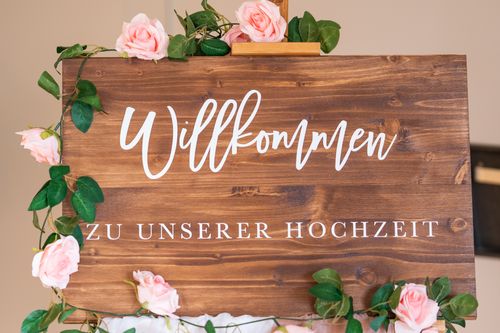 Free Wooden welcome sign adorned with pink roses for a wedding celebration. Stock Photo