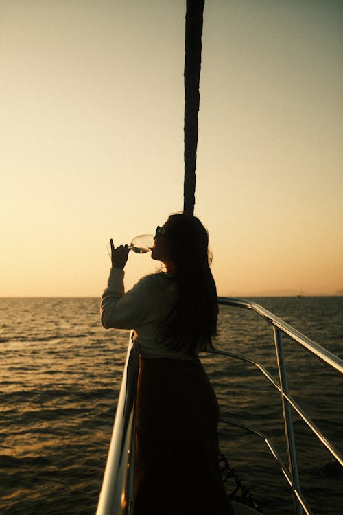 Woman Drinking on Vessel at Dusk