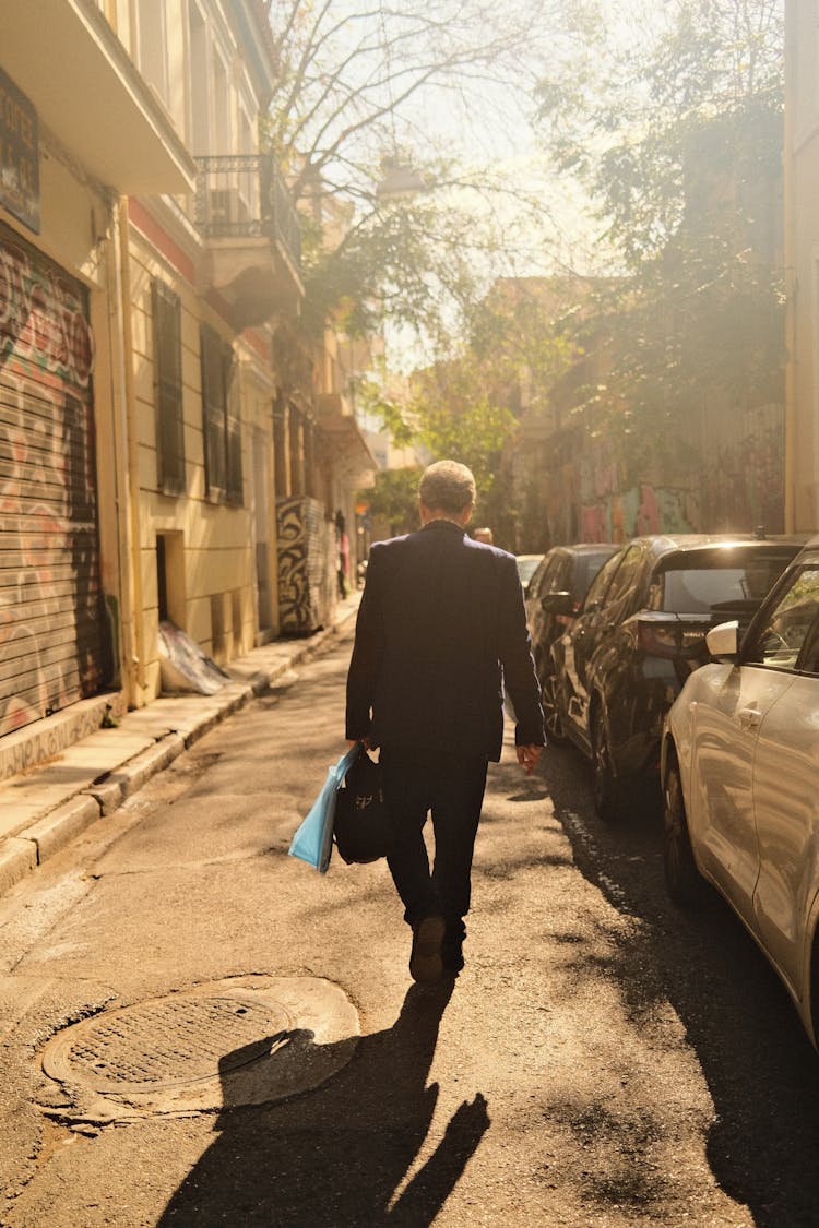 Man In Suit Walking On Street In Town