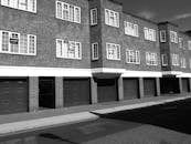 黑白照片中的城市公寓楼立面，带有砖砌外墙和窗户