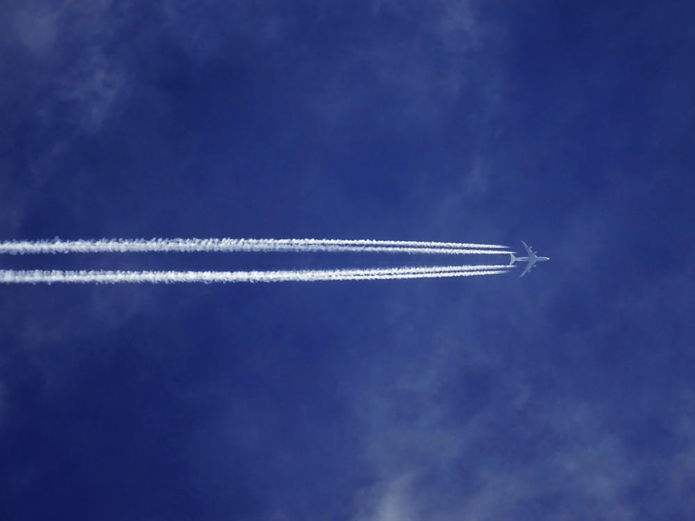 Bottom View of Plane With Contrail