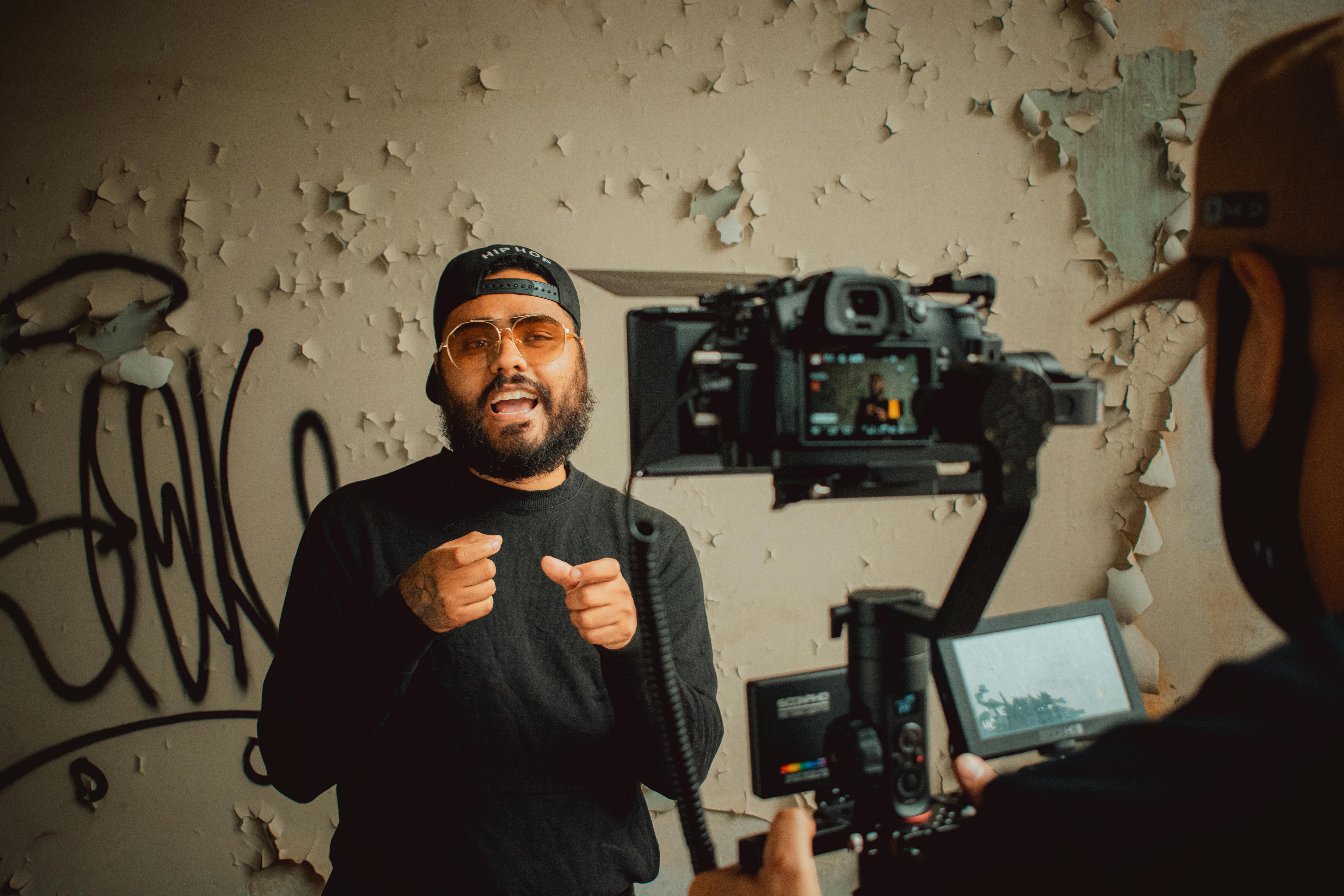 Hip-hop artist passionately performing during an indoor music video recording session.