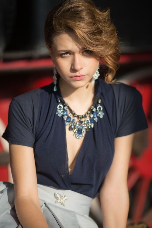 Free Stylish young woman wearing blue dress with exquisite jewelry, sunlit shot. Stock Photo