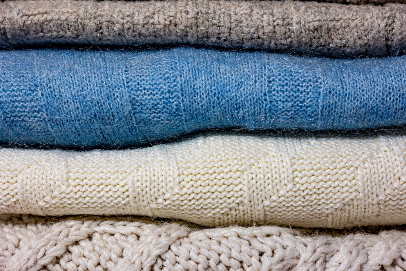 Stack of folded knitted wool blankets, photo by Aliaksei Semirski on Pexels