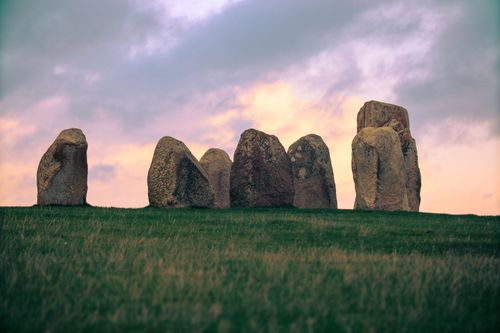 Free A serene landscape featuring megaliths under a colorful dusk sky. Stock Photo