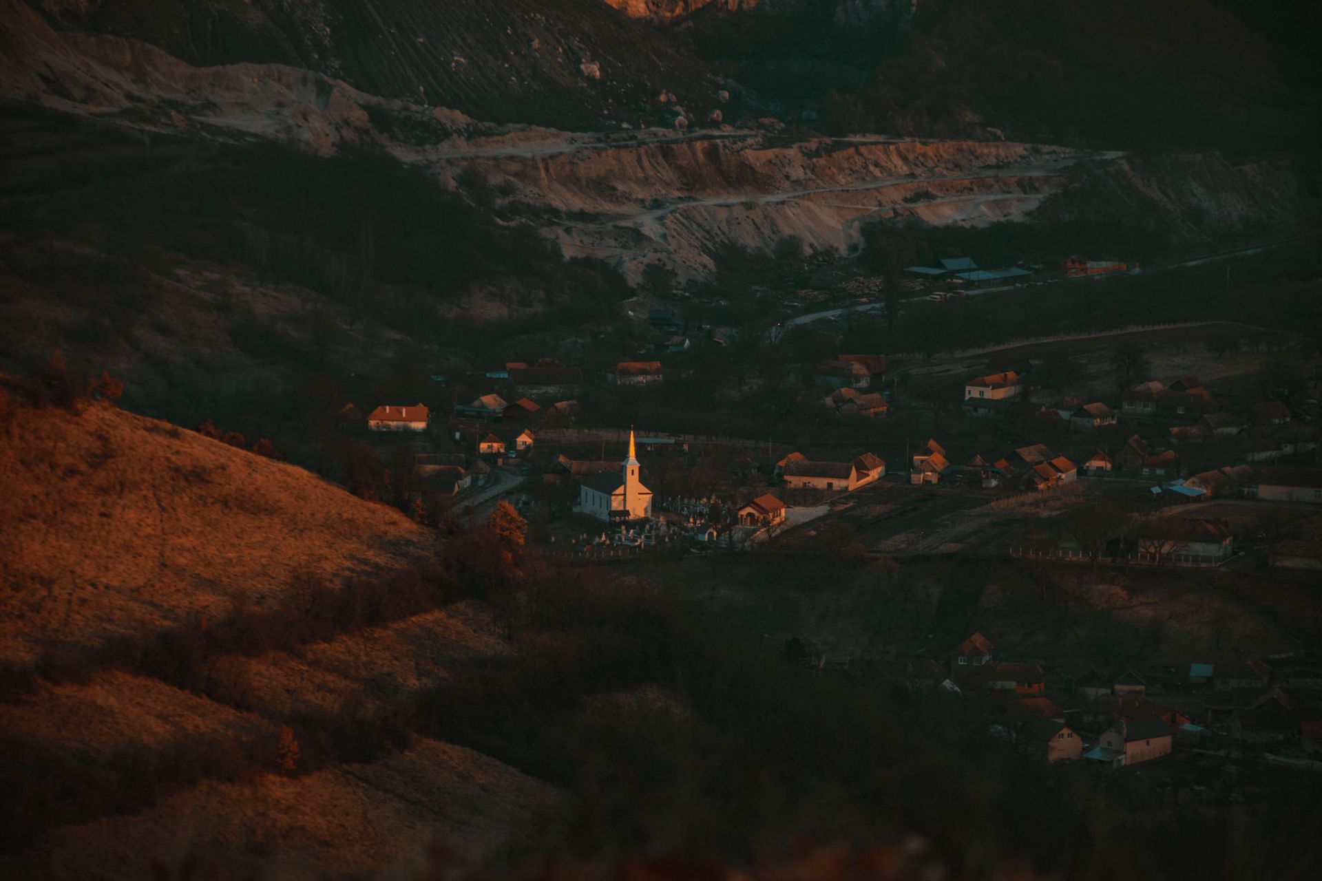 Aerial view of a church nestled in the valley of Alba Iulia, România at sunset.