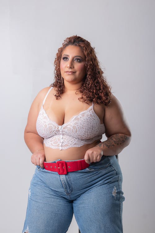 Young Woman with Curly Hair Posing in Jeans and Lace Top 
