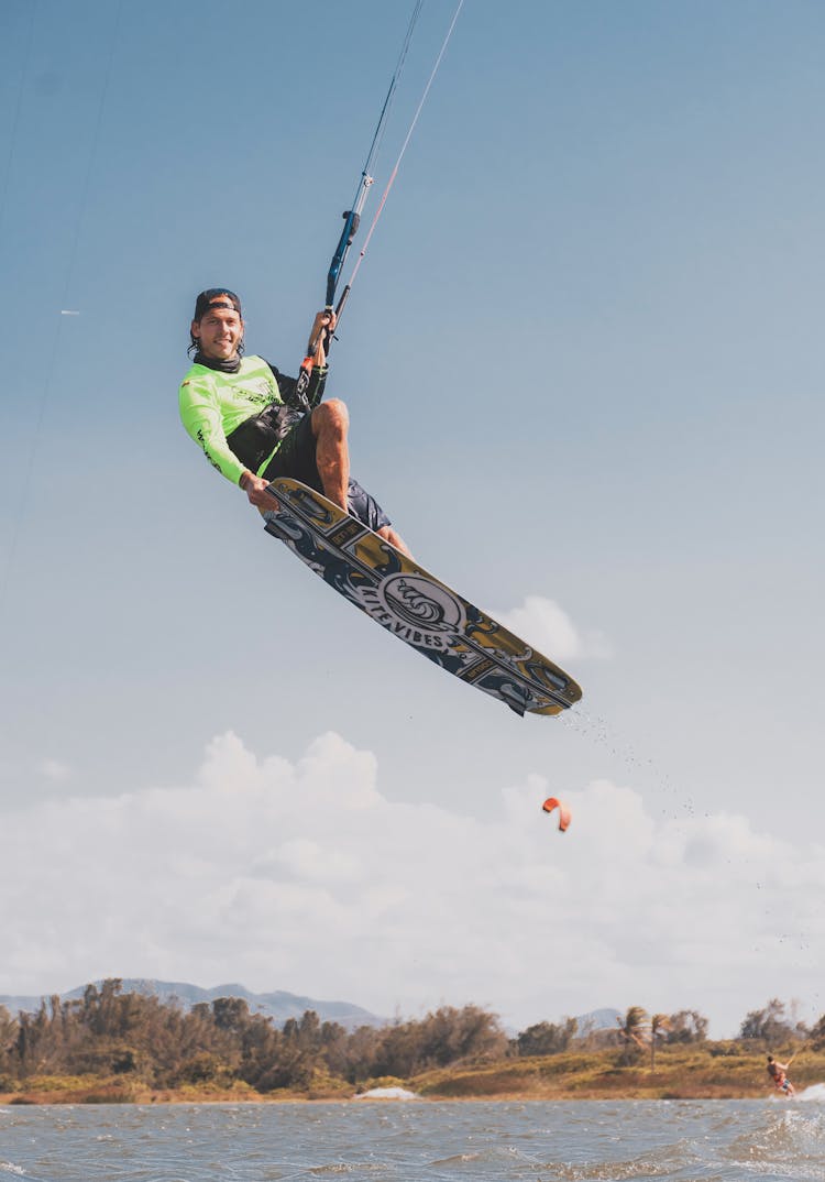 Man On Board Windsurfing In Water