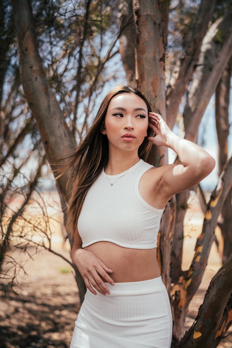 Young Woman In A White Outfit Posing Outdoors