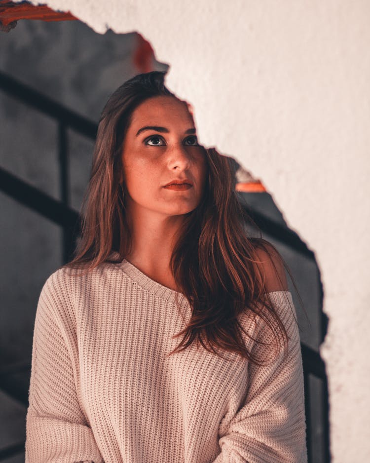 Close-up Photo Of Woman Near Broken White Wall