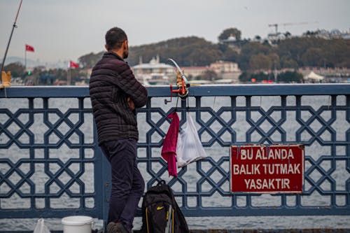 Man Fishing on a Bridge 