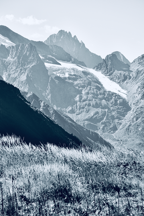 Free Stunning black and white photo of rugged mountain peaks and grassy foreground. Stock Photo