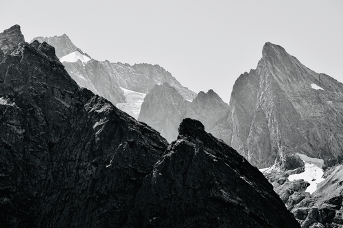 Free Black and white photo of rugged mountain peaks with snowy patches. Stock Photo