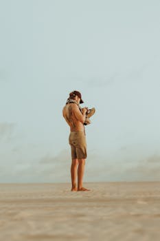 Man standing on a sandy beach at sunset in Canoa Quebrada, Brazil.