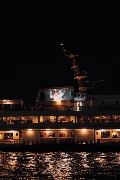 Free A ferry boat illuminated at night on the river, showcasing a relaxed and calming atmosphere. Stock Photo