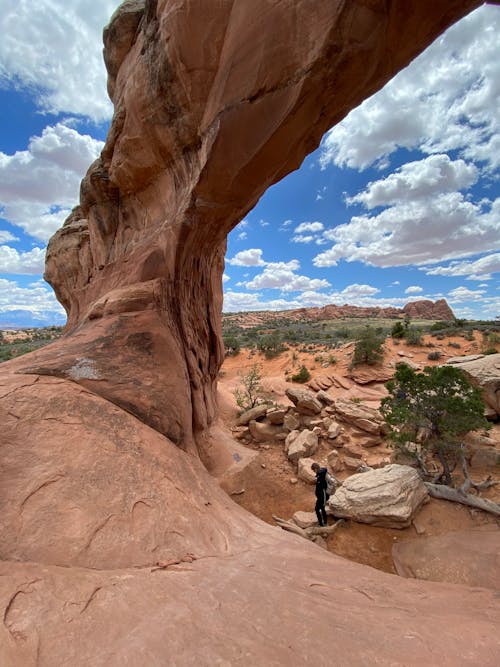 Man Standing under Natural Arch