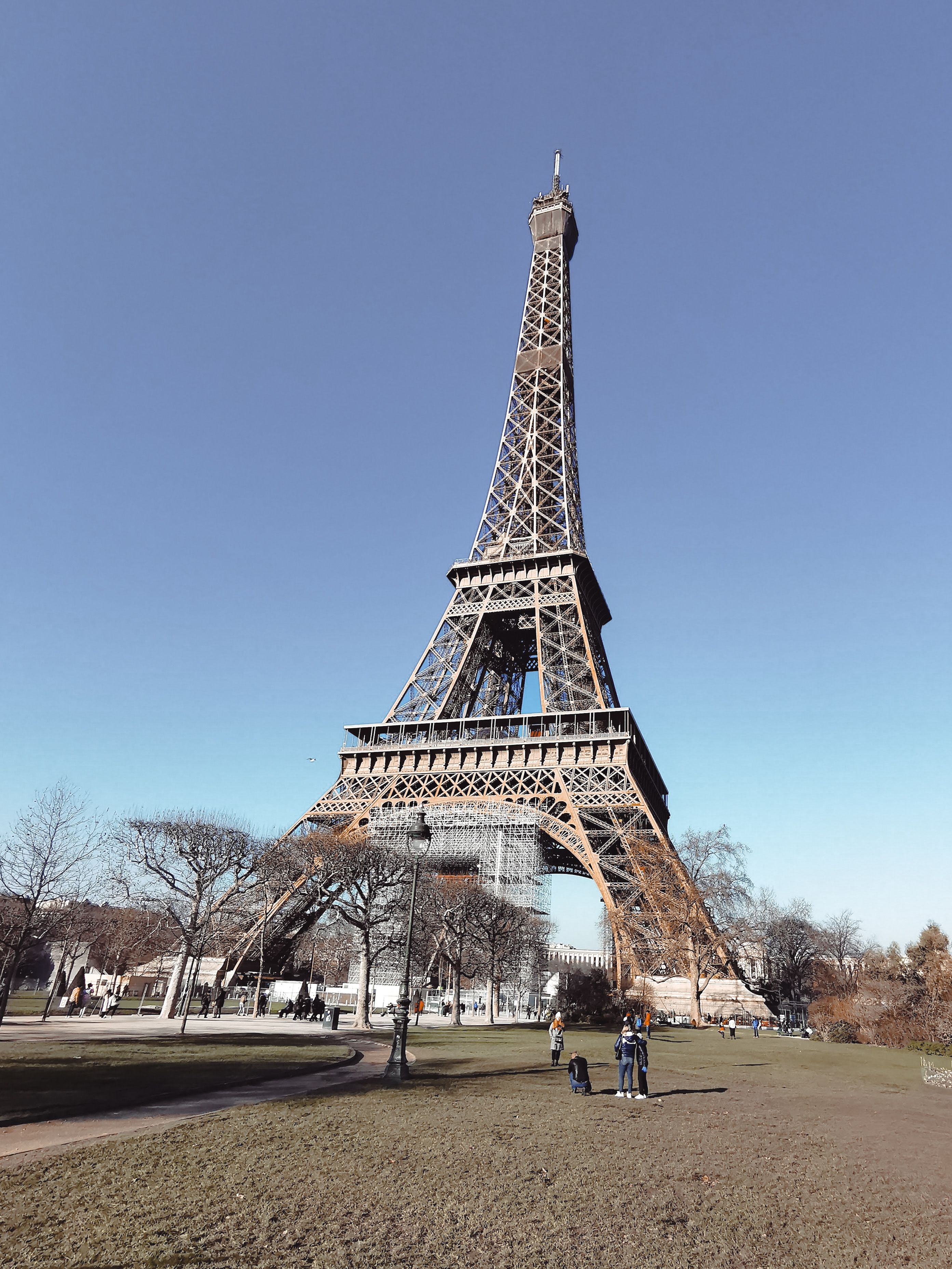 The iconic Eiffel Tower in Paris against a clear blue sky, showcasing its grandeur as a famous landmark.