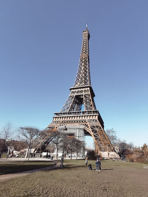 Free The iconic Eiffel Tower in Paris against a clear blue sky, showcasing its grandeur as a famous landmark. Stock Photo