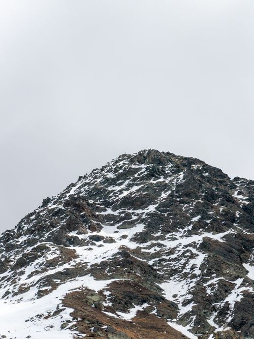 Free Majestic snowcapped mountain peak under an overcast sky, showcasing nature's raw beauty. Stock Photo