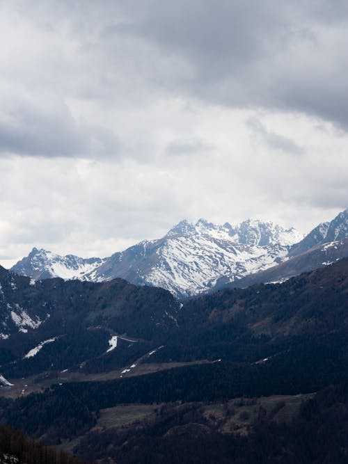 Snow Covered Mountains Under Cloudy Sky