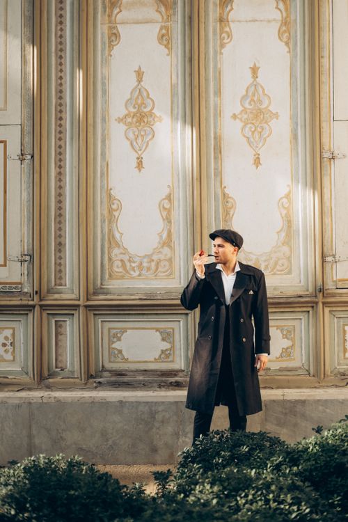 Free A man in a chic black coat poses with elegance at a historic palace in Istanbul, Turkey. Stock Photo