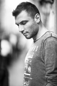 黑白街景肖像中，一位留着胡须的男子正在沉思