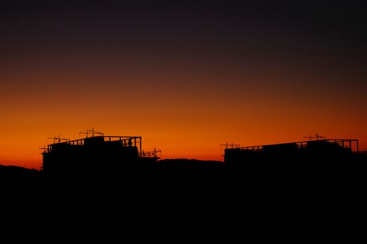 A breathtaking view of urban silhouettes against a vibrant orange sunset.