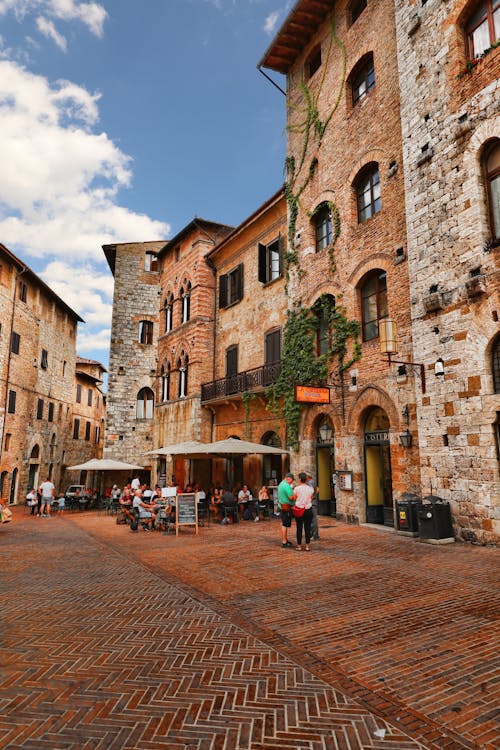 People Standing Beside the Brown Brick Building