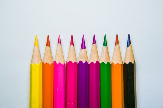 A vibrant lineup of sharpened color pencils on a white background.