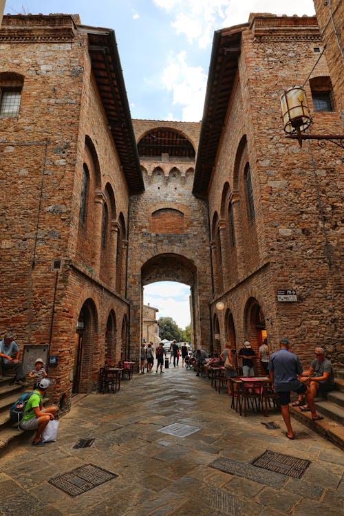 People Walking Beside Brick Buildings