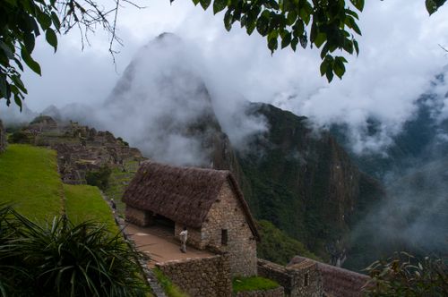 Free A fog-laden landscape at Machu Picchu with ancient stone structures and lush greenery. Stock Photo