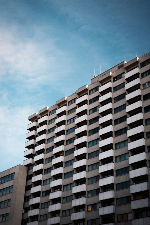 Free Contemporary high-rise apartment building with balconies against a blue sky in Berlin. Stock Photo