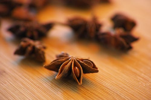 Selective Focus Photography of Star Anise on Top of Wooden Surface