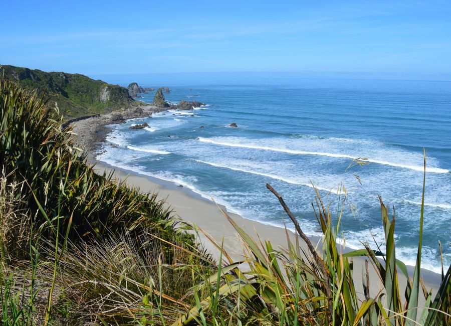 Explore the tranquil coastline of Westport, New Zealand with waves gently crashing on the shore.