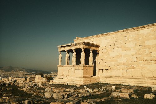 Free Ancient Caryatids on the Erechtheion at the Acropolis, Athens. Historic architecture under a clear sky. Stock Photo
