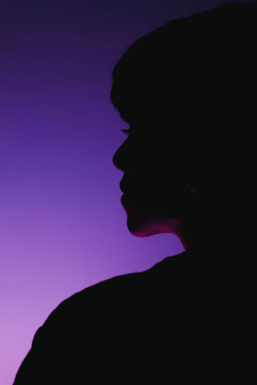 Free Artistic silhouette of a woman's profile against a purple gradient background Stock Photo