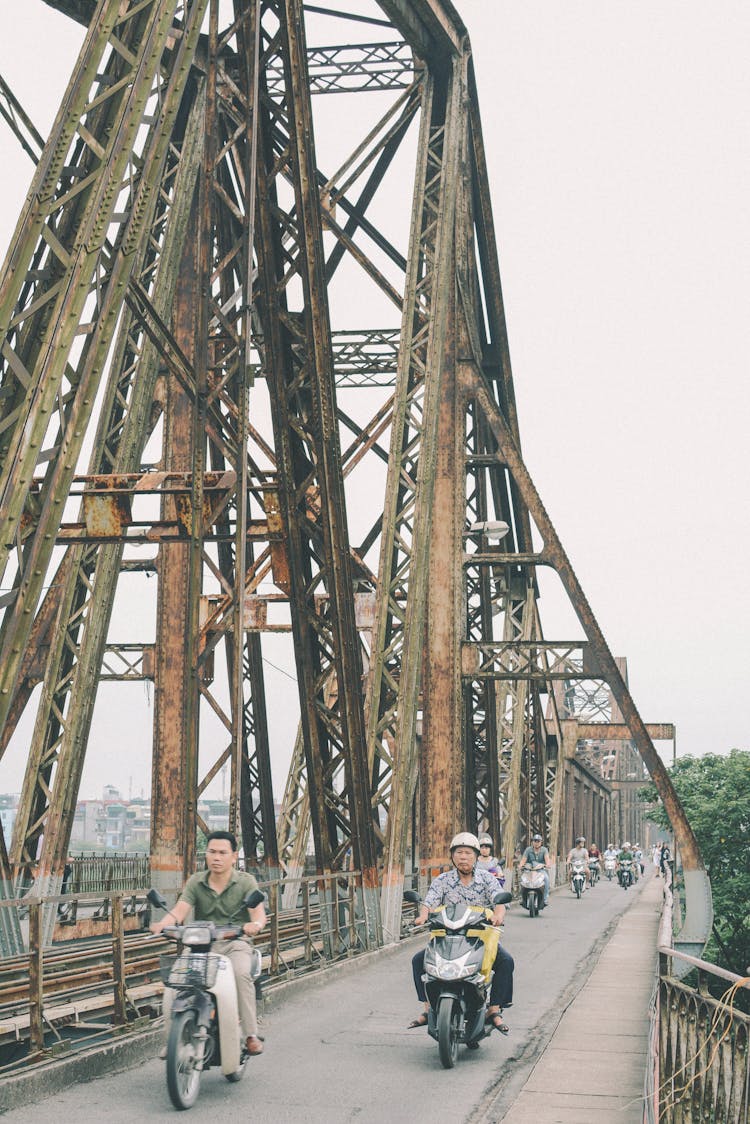 People Driving Motorcycles On Bridge