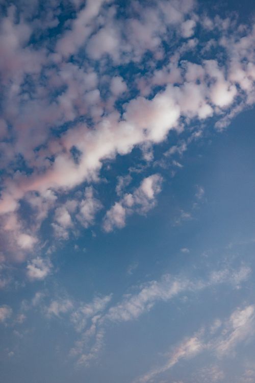 Free Peaceful sky featuring an array of fluffy white clouds against a blue backdrop. Stock Photo