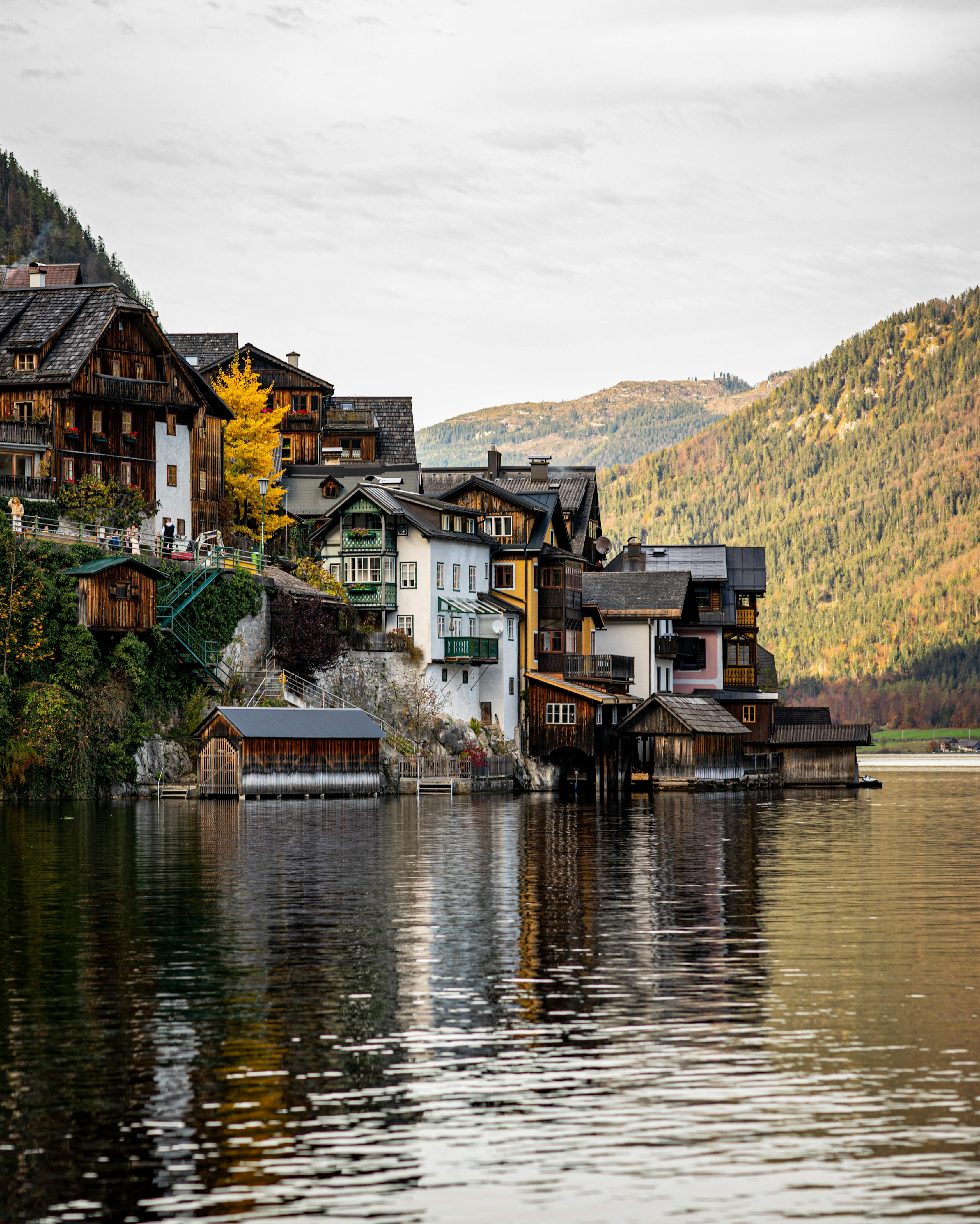 Picturesque lakeside view of Hallstatt village reflecting in the water during autumn.