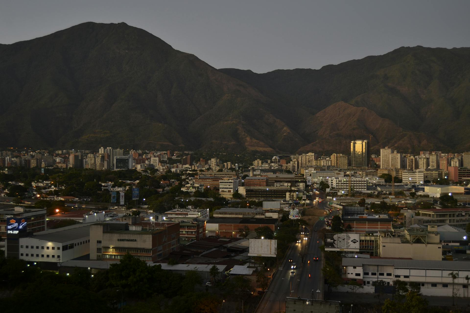 An aerial view of Caracas, Venezuela, showcasing cityscape with mountains at twilight.