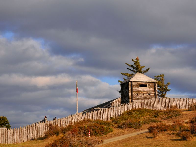 A reconstructed wooden stockade fort on a grassy hill