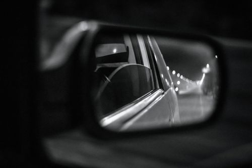 Free A monochrome shot of a car’s side mirror reflecting the road in focus. Stock Photo