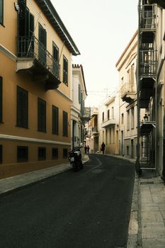 European street with vintage buildings and narrow alley at daytime, featuring warm tones and traditional style.