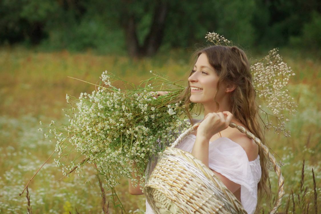 A Woman in White Dress Holding Flowers · Free Stock Photo