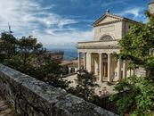 Scenic view of the Basilica in San Marino surrounded by trees on a sunny day.