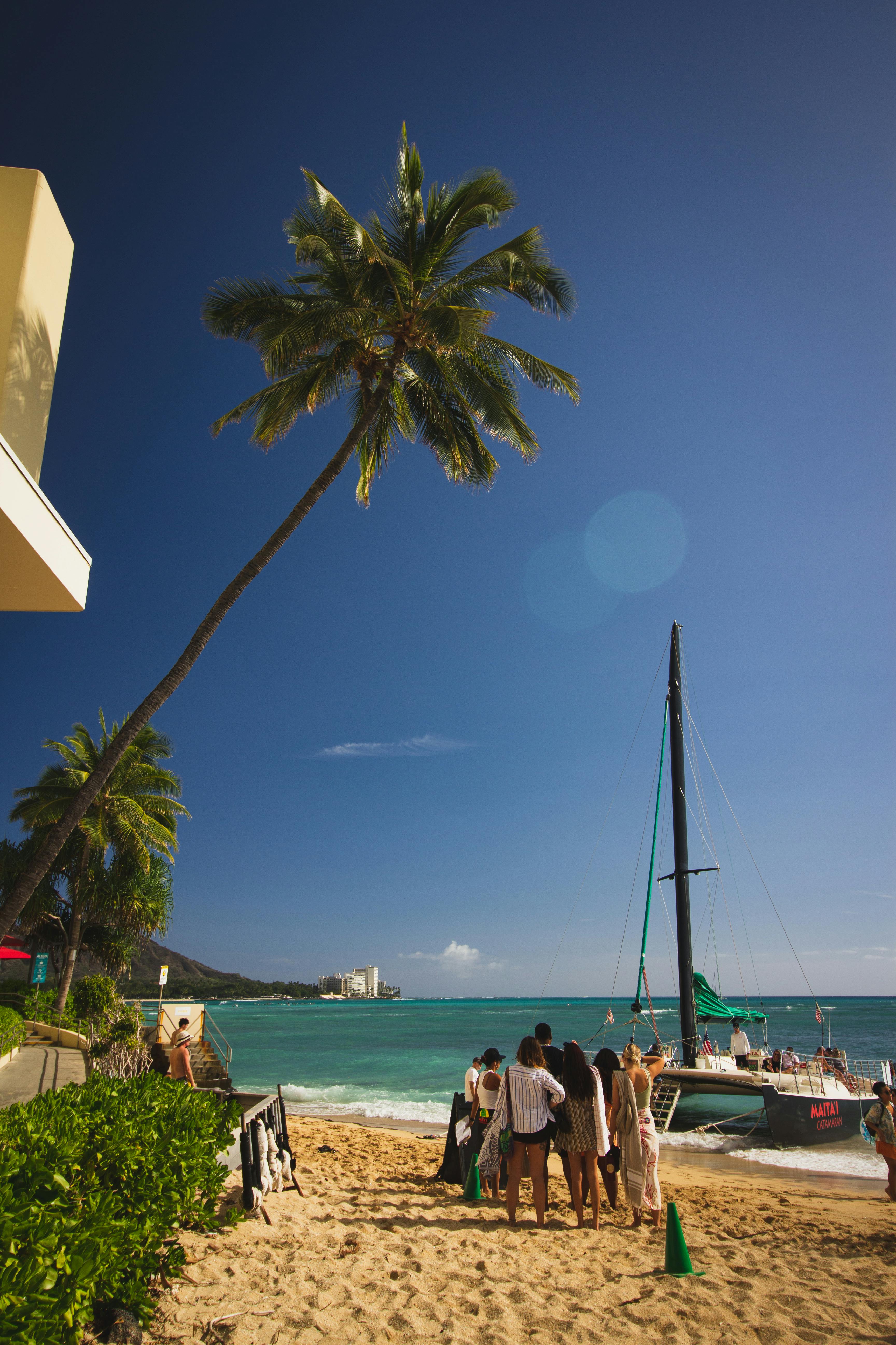 group of tourists on a tropical beach before boarding a tour boat